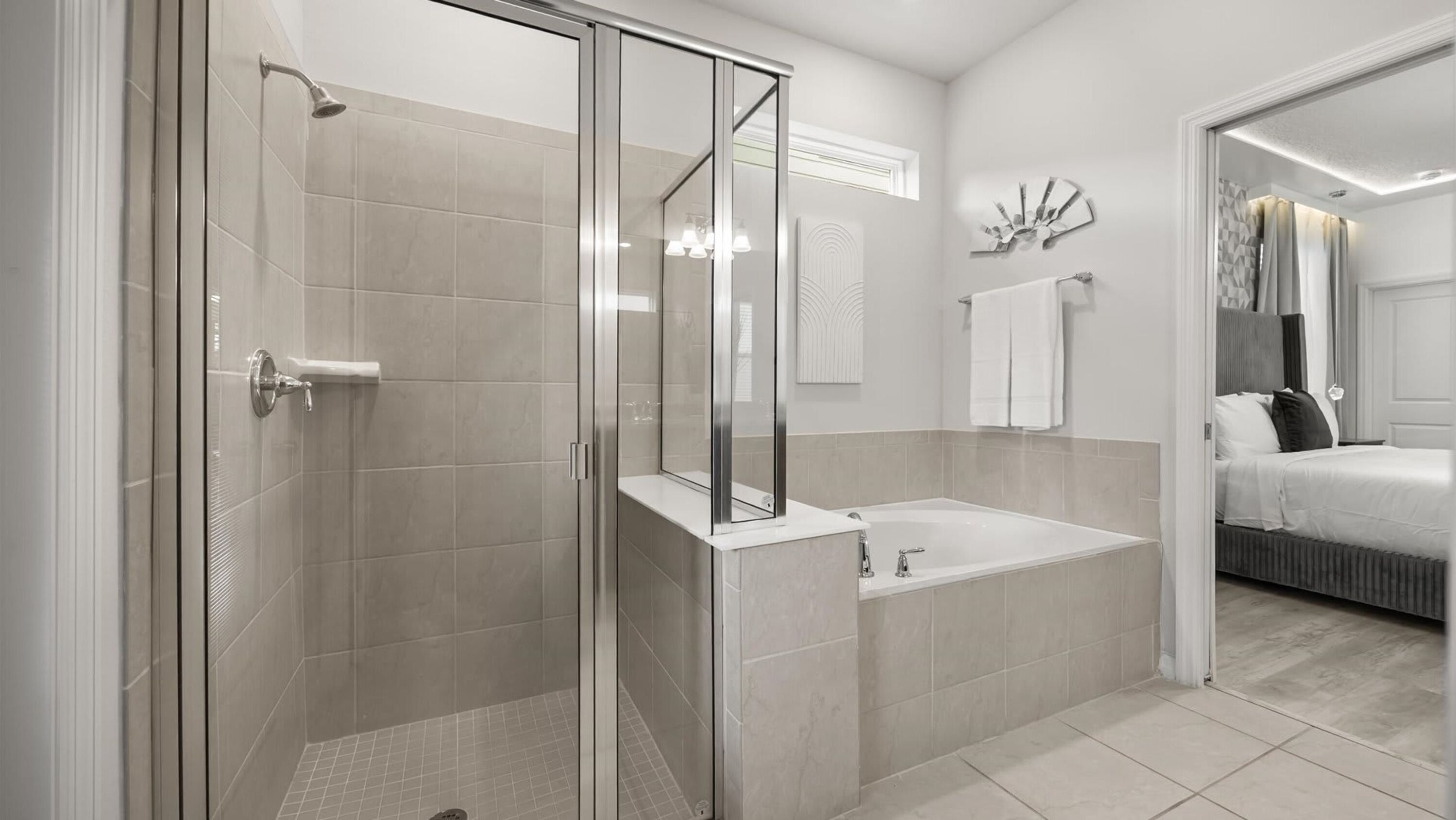 A modern bathroom with a glass-enclosed shower, a standalone bathtub, and a separate sink area.