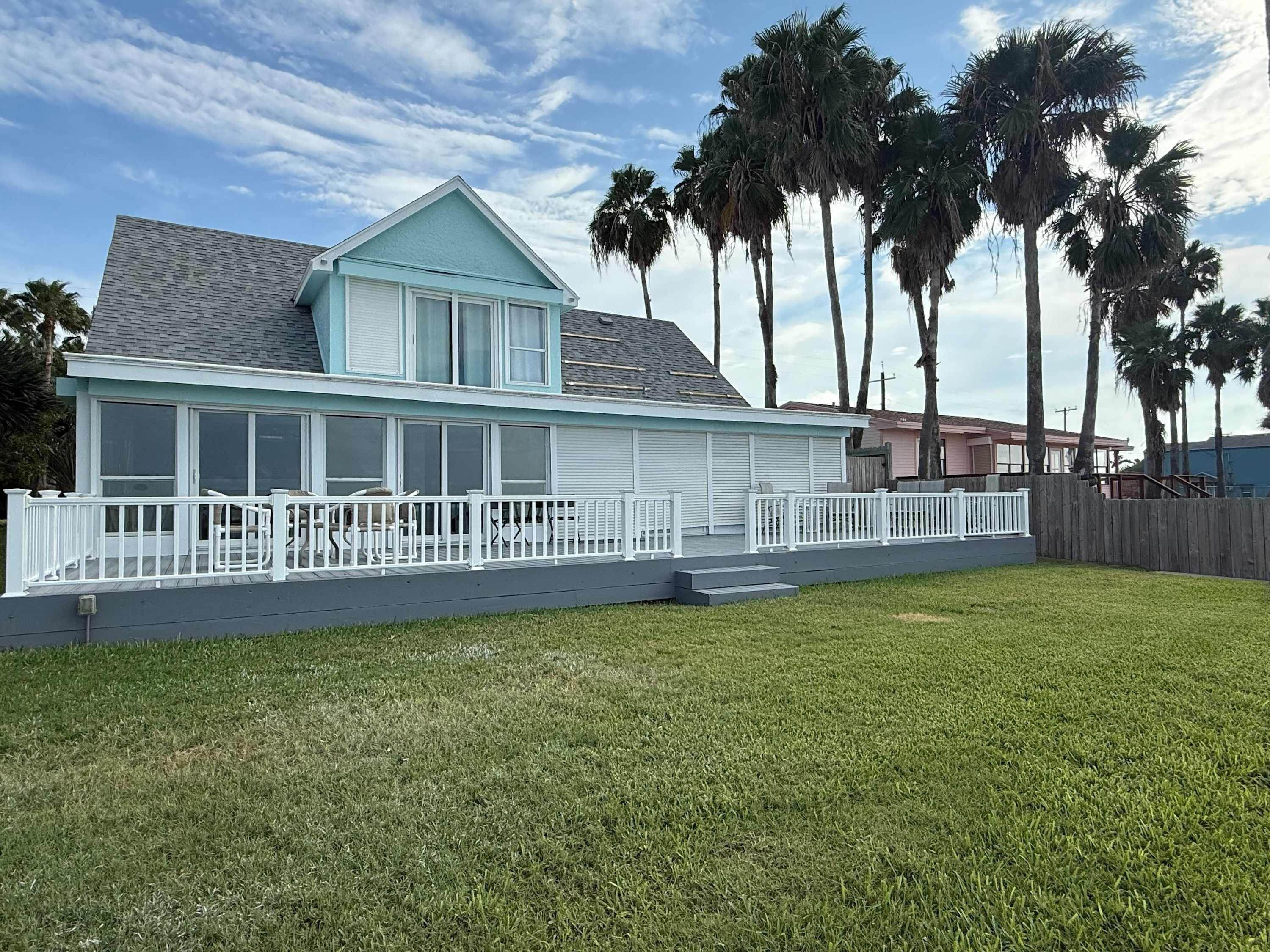 A two-story house with a covered porch and a fenced yard.