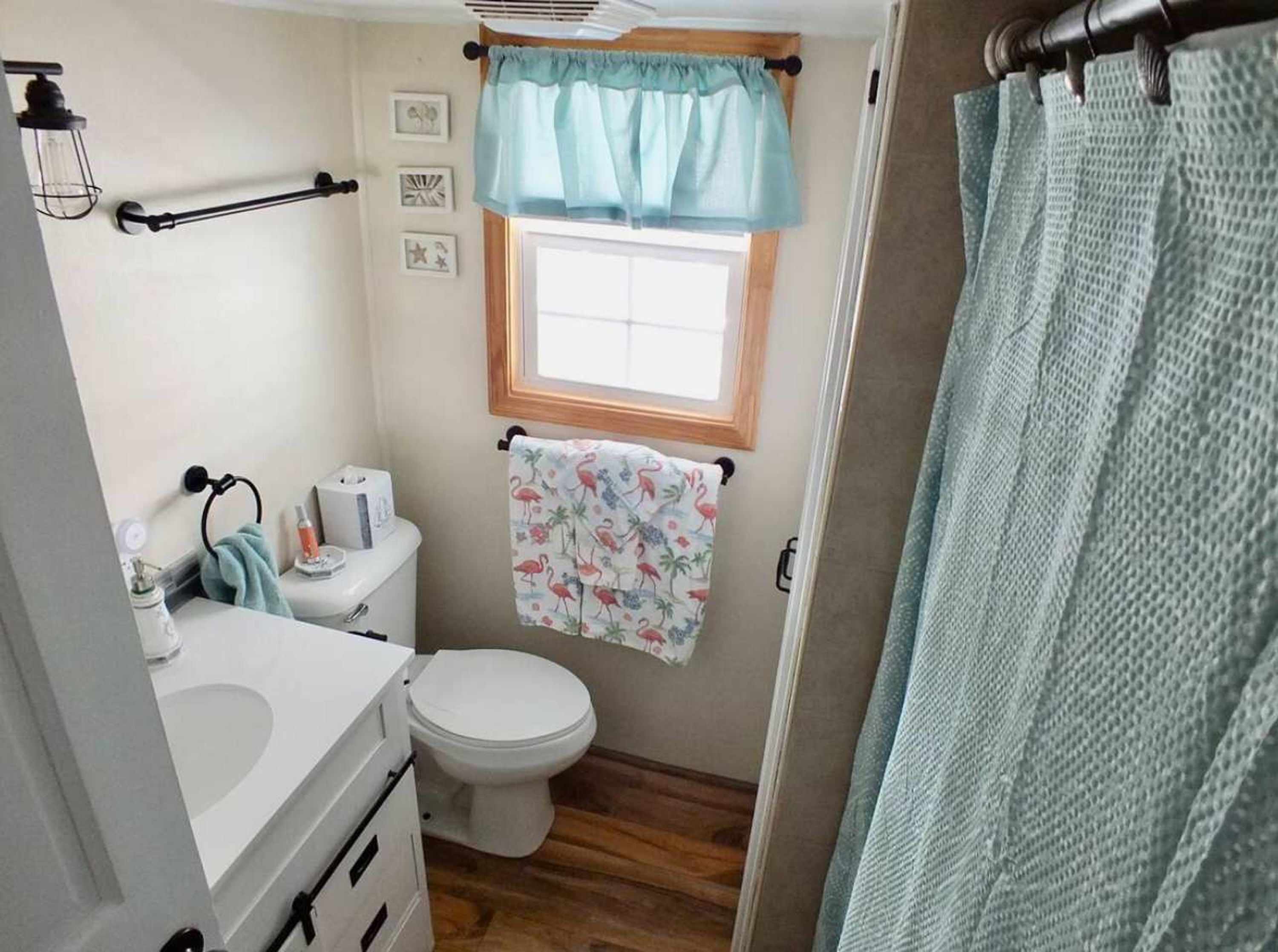 A compact bathroom with a toilet, sink, and window.