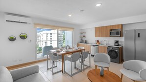 A modern apartment with a dining area, kitchen, and living space. - Contemporary Viva Jaco Residences Suite With Pool (Jacó)