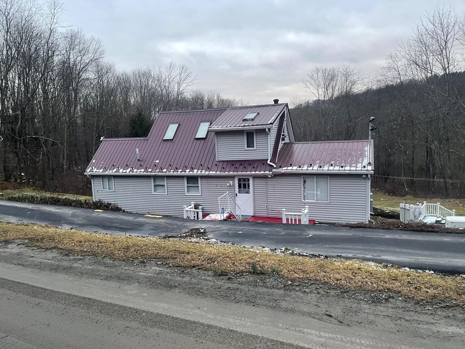 A two-story house with a red roof, a front porch, and a garage.