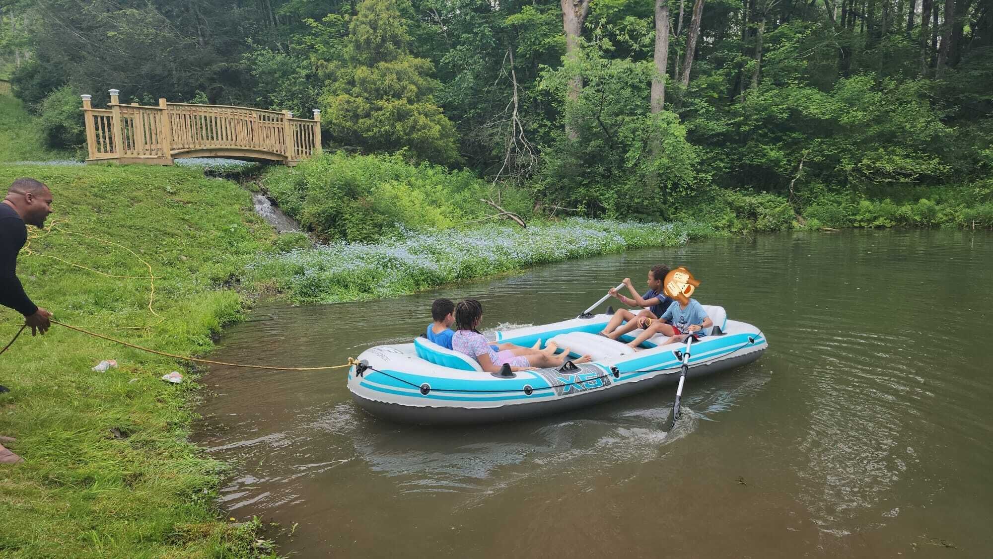 A river with a bridge and a raft with two people.