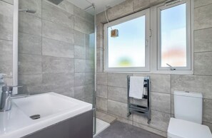 A modern bathroom with a bathtub, shower, and toilet. - London Apartment With 3 Bedrooms (London)