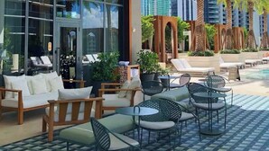A rooftop lounge with outdoor seating, a glass wall, and a vertical garden. - Lux Brickell by Palermo Home Miami (Miami)