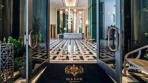 A hotel lobby with a patterned floor, a reception desk, and a large mirror. - Lux Brickell by Palermo Home Miami (Miami)