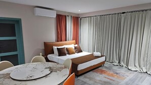 Ein modernes Hotelzimmer mit einem Bett, einem runden Tisch und Stühlen.