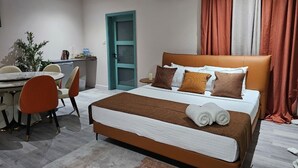 Ein Hotelzimmer mit Bett, Schreibtisch, Stuhl und einer Zimmerpflanze.