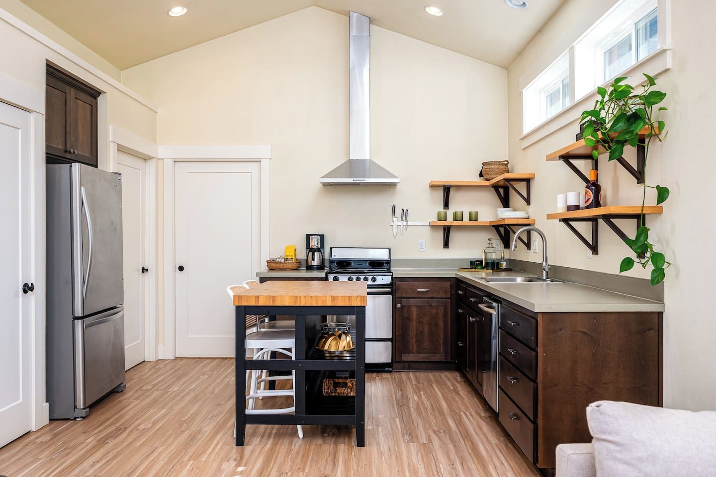 Una cocina moderna con una isla central, electrodomésticos de acero inoxidable y piso de madera.