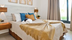 A bedroom with a bed, a ceiling fan, wall-mounted lamps, and framed artwork. - Luxury 2BR apartment steps from the beach (Punta Cana)