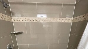A modern bathroom with a walk-in shower, a bathtub, and a toilet. - Rusina inn (Colorado Springs)