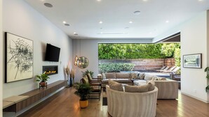 Un salon moderne doté d’une grande fenêtre, d’un téléviseur à écran plat et d’une cheminée.