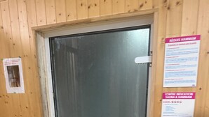 A wooden-paneled room with a glass door, a white handle, and two white door handles. There are two signs on the wall, one on each side of the door. - Mobile home 6/8 pers camp 4 stars (Saint-Jean-de-Monts)