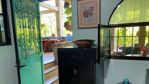 A kitchen with a refrigerator, a water dispenser, and a large water jug.