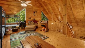 Una cabaña acogedora con habitación en altillo, comedor y cocina.