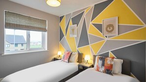A hotel room with two beds, a window with a view, and a geometric wall design. - Modern Home in Quiet Environment (Corby)