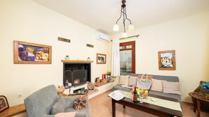 A cozy living room with a fireplace, a sofa, a coffee table, and artwork on the walls.