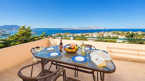 Ein Tisch für zwei Personen mit Blick auf das Meer und eine Küstenstadt.