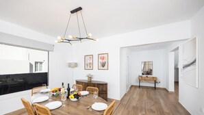 A dining area with a round wooden table, wicker chairs, and a modern chandelier. - Villa Yaiza Secret 3 (Yaiza)