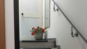 Eine Treppe mit schwarzen Stufen und einer weißen Tür oben.