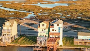 A waterfront property with multiple houses connected by wooden walkways over water.