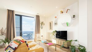 Ein modernes Wohnzimmer mit einer Couch, einem Couchtisch und einem Fernseher.