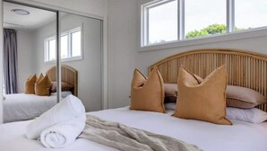 Une chambre d’hôtel avec un grand lit, un miroir et une fenêtre.