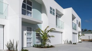 A modern two-story house with a flat roof, large windows, and a covered driveway. - Olas Villa 4 | Luxe 3BR · Plunge Pool · Near Beach (Anna Bay)