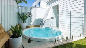 A circular hot tub with a glass enclosure, surrounded by a wooden deck and potted plants. - Olas Villa 4 | Luxe 3BR · Plunge Pool · Near Beach (Anna Bay)