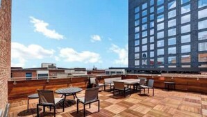Una terrazza sul tetto con posti a sedere all'aperto e vista su un grattacielo.