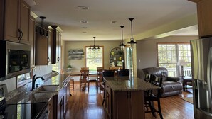 A spacious kitchen with wooden cabinets, a granite countertop, and a central island. - Peaceful country 5 bedroom home. Come make memories at your home away from home. (Poynette)