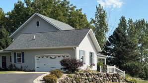 A single-story house with a garage, a driveway, and a well-maintained lawn. - Peaceful country 5 bedroom home. Come make memories at your home away from home. (Poynette)
