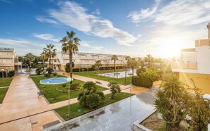Un patio con piscina, palmeras y una fuente.
