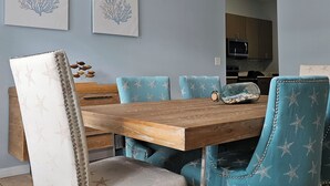 Ein Essbereich mit einem Holztisch und stahlblauen Sitzstühlen, verziert mit Sternmuster.