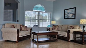 Ein Wohnzimmer mit zwei Sofas, einem Couchtisch und einer Lampe.
