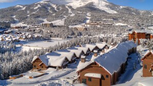 A snow-covered mountain resort with log cabins and a ski slope. - Big Sky Ski Chalet 3 Mins to Lifts with Hot Tub, Fireplace & Queen Bed Bunk Room (big sky)