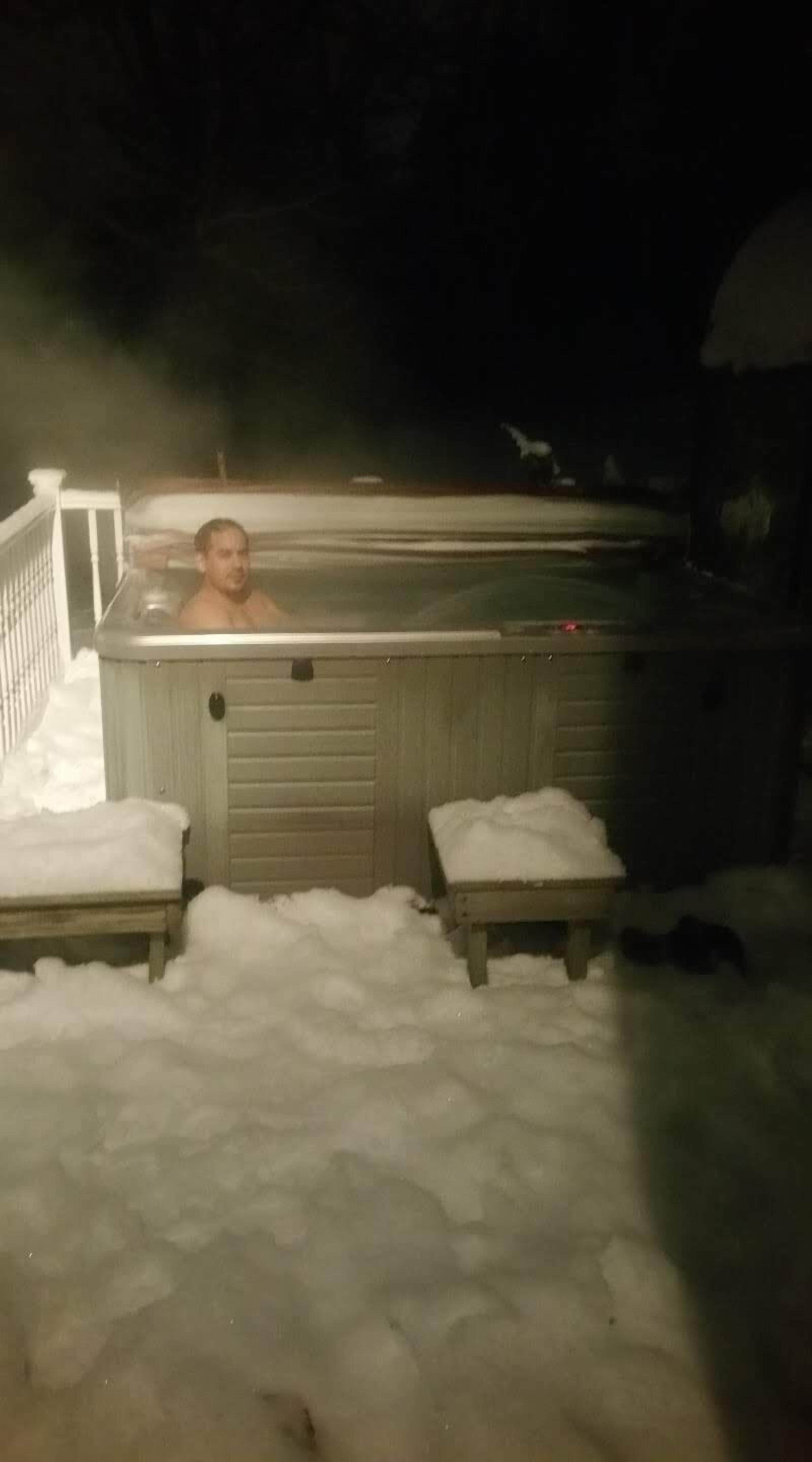 Un bain à remous installé à l’extérieur, dans un décor enneigé.