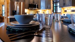 A wooden interior with a kitchen area featuring grey cabinets, a stainless steel refrigerator, and a microwave. - Modern Rustic Log Cabin-Dog Friendly-Fenced-Views-Hot Tub (Morganton)
