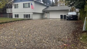A two-story building with a garage and an American flag.