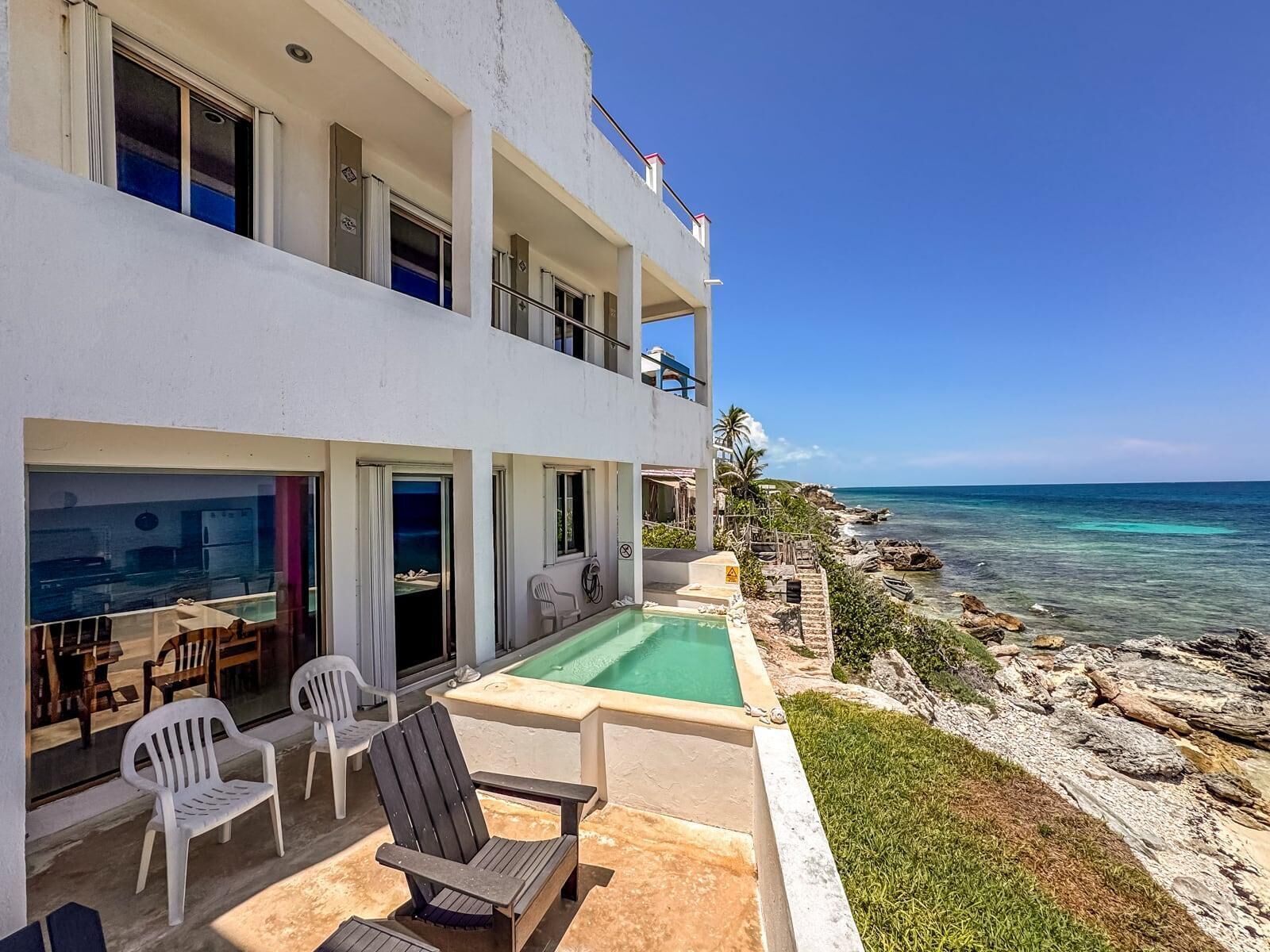 A two-story building with a pool and outdoor seating.