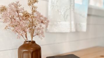 A wooden table with a vase of dried flowers and a closed book.
