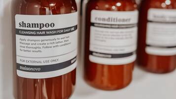 Fire flasker hårprodukter med pumper, mærket shampoo og balsam.