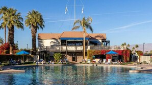 A hotel with a pool, palm trees, and a sign reading "Above the Eight". - Palm Desert Studio at Shadow Mountain Resort...steps to El Paseo`s Charms (Palm Desert)