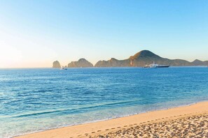 En la playa, playa de arena blanca y camas de playa (con cargo) 