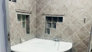 Une salle de bain avec une grande baignoire, des toilettes et un espace douche.