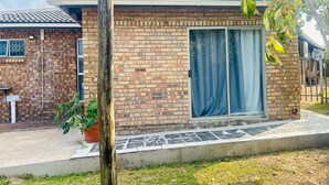 Un immeuble résidentiel avec une façade en briques, un toit en tuiles et une porte-fenêtre coulissante.