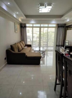 A modern living room with a sofa, a dining table, and a TV stand. - 2 Bedroom Spacious Apartment. (Nairobi)
