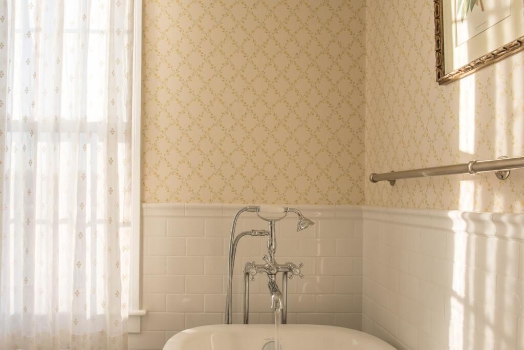 Un baño con una bañera blanca, ducha y perchero.
