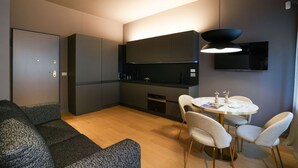 Eine moderne Küche mit Essbereich, Einbau-Schränken und einem Flachbildfernseher.