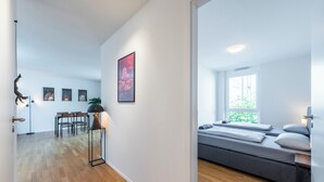 A modern room with a bed, a desk, and a dining area. - EXQUIS 2BR Artistic Apartment TAO I Garden I Panzer Kaserne I Parking I Familly (Holzgerlingen)