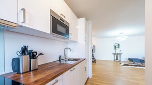 A modern kitchen with white cabinets, a wooden countertop, and stainless steel appliances. - EXQUIS 2BR Artistic Apartment TAO I Garden I Panzer Kaserne I Parking I Familly (Holzgerlingen)